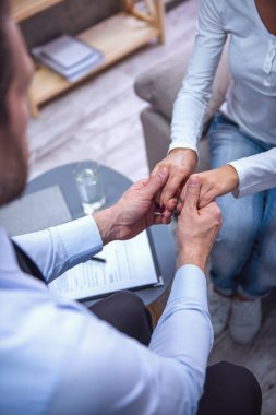 Psikolog. Bir kadın yatıştırıcı ve ellerini tutarak doktor Resim kırpılmış