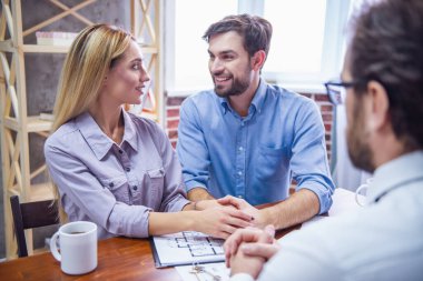 Güzel çift takım elbiseli yakışıklı Emlak konuşurken ve gülümseyen