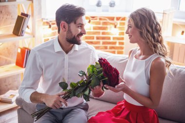 Yakışıklı olan zarif onun güzel kız arkadaşı gül veren ve onlar evde romantik bir tarih olan gülümseyen