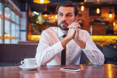 Kafede kahve molası sırasında yakışıklı dalgın işadamı uzak ve düşünme arıyor