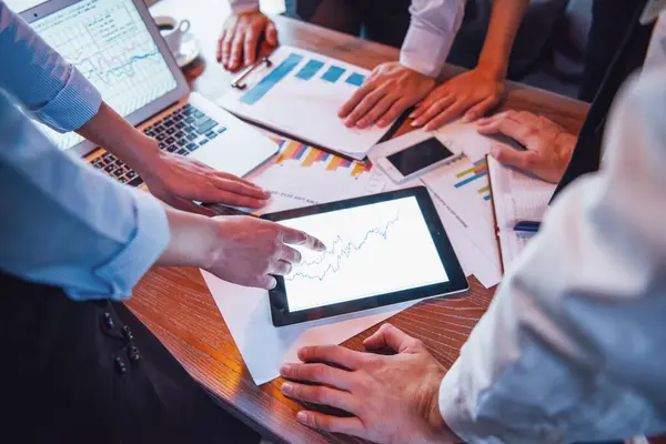 stock image Cropped image of business people using gadgets and studying documents while working in cafe