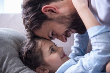 Sevimli küçük kız ve yakışıklı babası sarılma ve birlikte evde oynamak
