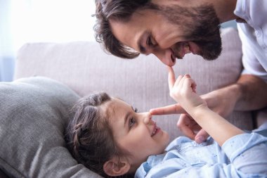 Sevimli küçük kız ve yakışıklı babası sarılma ve birlikte evde oynamak