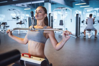 Çekici genç kadın üzerinde spor salonu, fitness merkezinde demir pompalama çalışıyor