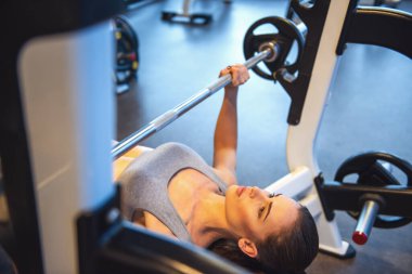 Çekici genç kadın spor salonunda dışarı çalışırken ağırlık kaldırma