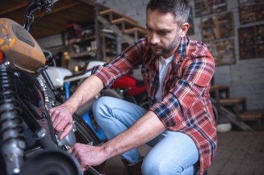 Yakışıklı adam bir motosiklet tamircisi onarıyor