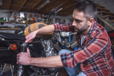 Yakışıklı adam bir motosiklet tamircisi onarıyor