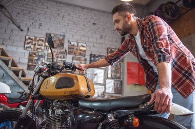 Yakışıklı adam bir motosiklet tamircisi olarak incelenmesi