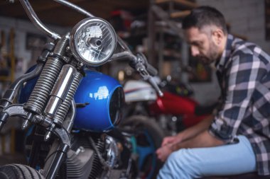 Yakışıklı adam bir motosiklet tamircisi onarıyor