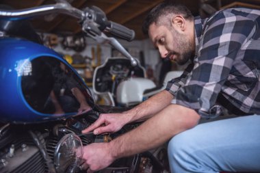 Yakışıklı adam bir motosiklet tamircisi onarıyor