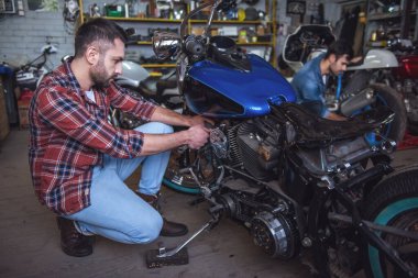 Yakışıklı çocuklar motosiklet tamir dükkanında tamir