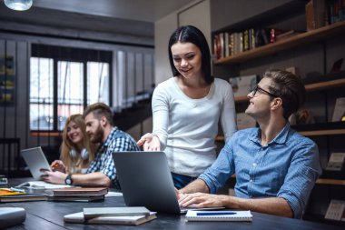 Araçları, söz ve modern kütüphanede okurken gülümseyen genç akıllı insanlar kullanma