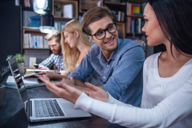 Gençler akıllı araçları kullanma ve çalışırken modern kütüphanede zor konuşuyor