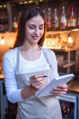 Güzel kadın barista notlar ve bar yakınındaki dururken gülümseyen Cafe counter