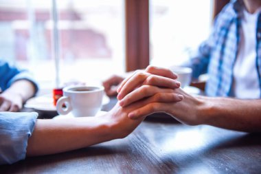 Mutlu genç çift kahve içme, konuşma ve kafede otururken gülümseyen