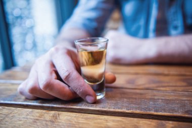 Bir adam bir kadeh alkol tutan gösterilen Resim kırpılmış