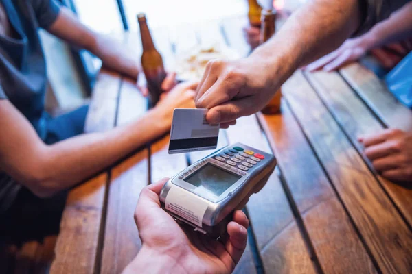 朋友在酒吧里休息时喝啤酒 裁剪图像的家伙支付使用信用卡 — 图库照片