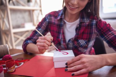 Onun çift için mevcut yaparken gülümseyen güzel romantik kızın kırpılmış görüntü
