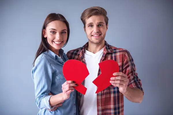 Heureux Jeune Couple Tient Deux Moitiés Coeur Papier Rouge Regardant — Photo