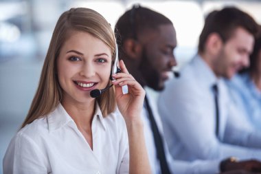 Çekici iş adamları takım elbise ve kulaklık dizüstü bilgisayarlar Office ile çalışırken gülüyorsun