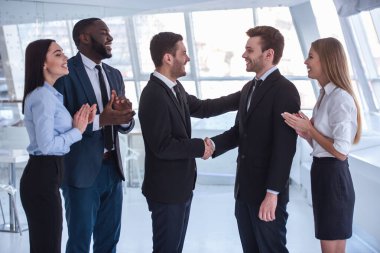 İki iş ortağı ofiste Elleri titriyor iken resmi elbiseli güzel iş adamları gülüyorsun