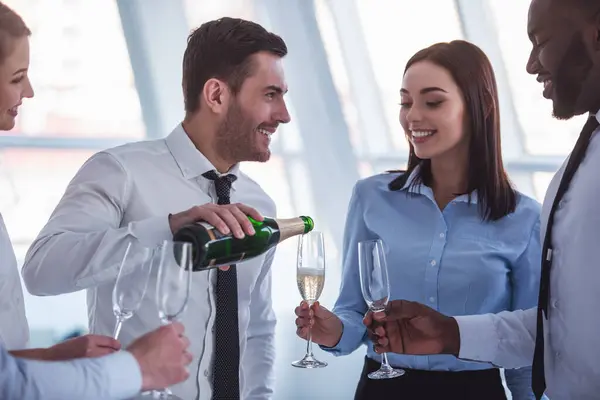 成功的商业人士都喝香槟 说话和微笑着庆祝在办公室 — 图库照片