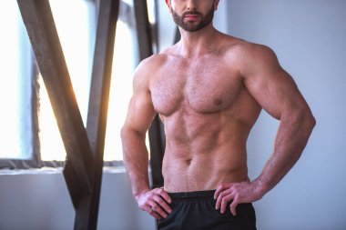 Çıplak gövde ayakta olan yakışıklı kaslı adam görüntüsünü spor salonunda akimbo kırpılmış