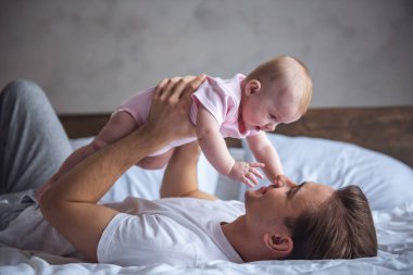 Yakışıklı genç Baba onun şirin bebek ile oynama ve gülümseyen