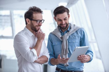 İki yakışıklı işadamları dijital tablet kullanma ve Office dururken gülümseyen