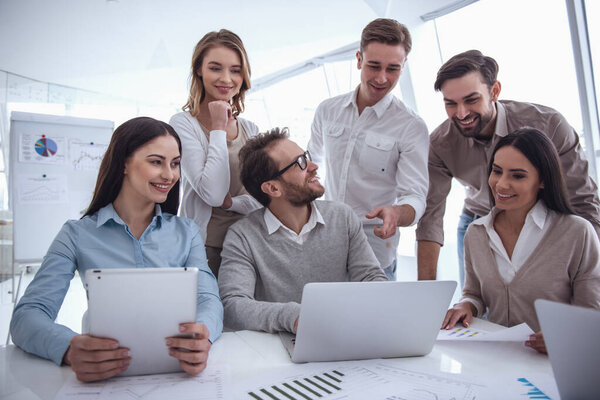 Деловые люди используют гаджеты, разговаривают и улыбаются во время конференции
