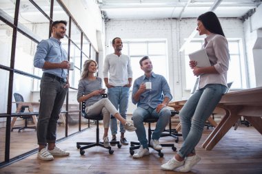 Güzel iş adamları konuşuyor, araçları kullanma ve ofisindeki kahve molası sırasında gülümseyen