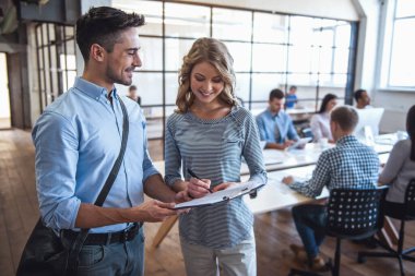 Yakışıklı teslimatçı ve güzel iş kadın konuşmak ve gülümseyen insanlar ofiste çalışıyoruz arka plan iş