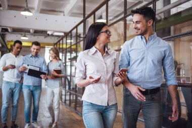 Araçları, konuşmak ve iş merkezi koridorda yürürken gülümseyen başarılı iş adamları kullanma