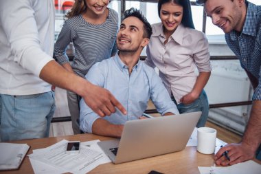 Güzel iş adamları konuşuyor ve Office toplantısında gülümseyen bir dizüstü bilgisayar kullanıyorsanız
