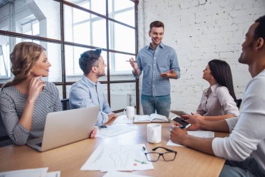 Araçları, kendi meslektaşı için dinleme ve Office toplantısında gülümseyen güzel iş adamları kullanma