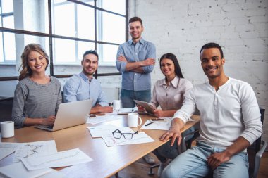 Araçları, kameraya bakarak ve Office toplantısında gülümseyen güzel iş adamları kullanma