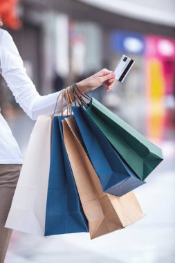 Güzel kızın alışveriş torbaları ve kredi kartı alışveriş merkezinde alışveriş yaparken kırpılmış görüntü