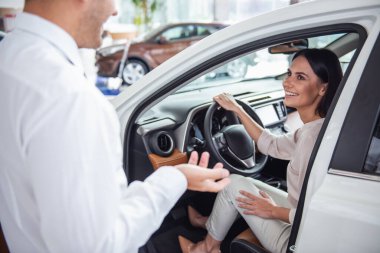 Güzel genç kadın yakışıklı araba Bayilik işçi için bir araba içinde Bayilik seçerken konuşuyor