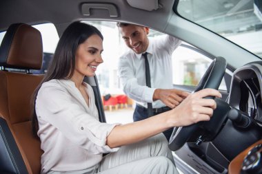 Güzel genç kadın yakışıklı araba Bayilik işçi için bir araba içinde Bayilik seçerken konuşuyor