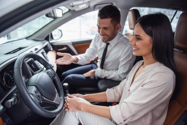 Güzel genç kadın yakışıklı araba Bayilik işçi için bir araba içinde Bayilik seçerken konuşuyor