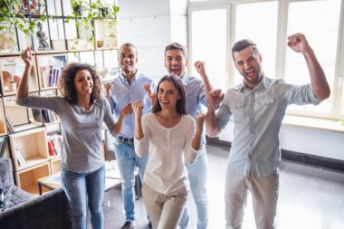 Başarılı iş adamları eller yumruk ve Office dururken mutluluk ile çığlık yükseltmektedirler