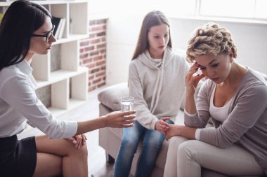 Anne ve genç kızı fizyoterapist ziyaret ediyor. Doktor ve genç sakinleştirici kadınsın