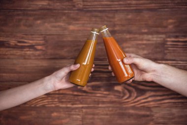 Besleyici kokteyller, ahşap arka plan üzerinde tutan genç spor insanlar görüntü kırpılmış