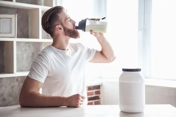 Handsome Young Bearded Sportsman Drinking While Preparing Sport Nutrition Kitchen — Stock Photo, Image