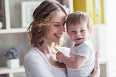 Güzel anne ile onun şirin bebek çocuk evde ve gülümseyen