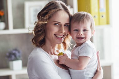 Güzel anne ile onun şirin bebek çocuk evde ve gülümseyen
