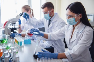 Eldiven, maske ve gözlük güzel tıp doktorları laboratuarda test tüpleri ve mikroskop maddeler ile çalışıyoruz