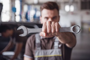 Otomatik mekanik üniformalı bir somun anahtarı ve kamera otomatik hizmetinde çalışırken bakarak el ile anahtar odak tutuyor