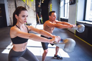 Güzel genç spor çift kettlebell spor salonunda çalıştığını