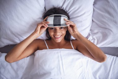 Üstten Görünüm. Güzel genç kadın kamera evde göz gülümseyen yatakta yalan